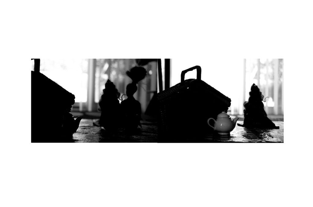 Silhouettes of picnic baskets, with a small teapot in the foreground.